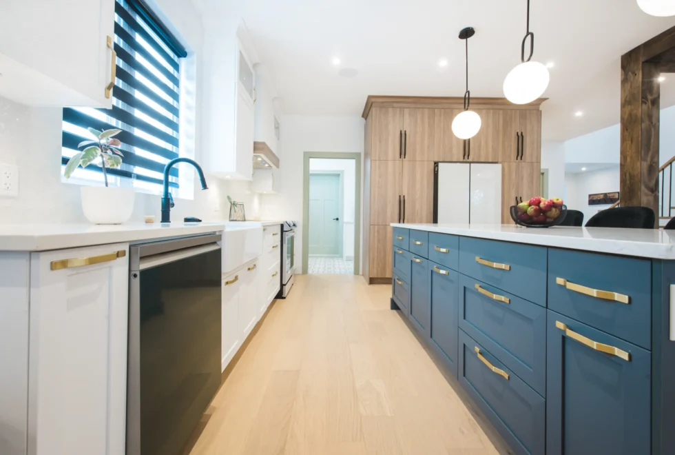 Passage de cuisine clair avec armoires blanches pleine hauteur et poignées dorées – projet d’aménagement réalisé par la designer Catherine Paradis.